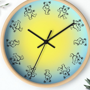 May include: A round wall clock with a yellow and blue gradient background. The clock face features black dancing bears around the edge and black clock hands.
