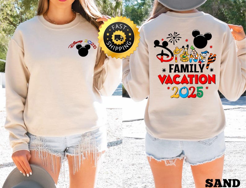 Puede incluir: Una sudadera beige con un gr&aacute;fico de Mickey Mouse en el pecho izquierdo y un gr&aacute;fico m&aacute;s grande en la espalda que dice "Disney Family Vacation 2025" con varios personajes de Disney y fuegos artificiales.