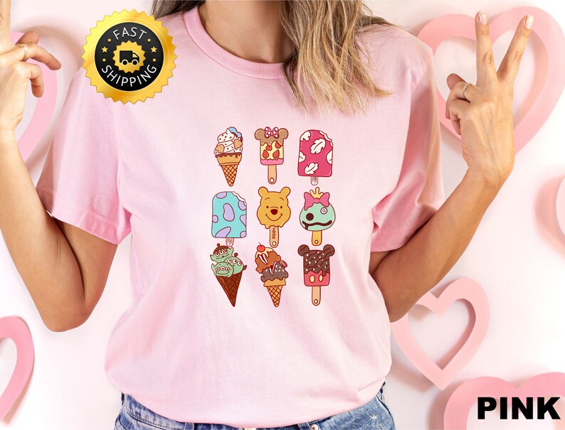 May include: Pink t-shirt with a graphic of various cartoon characters on popsicles and ice cream cones. The characters include Mickey Mouse, Minnie Mouse, Winnie the Pooh, and others.