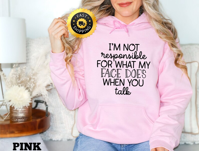 Puede incluir: Sudadera con capucha rosa con un gr&aacute;fico negro que dice "No soy responsable de lo que mi cara hace cuando hablas."