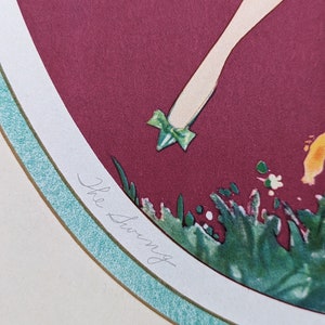 May include: An art print titled "The Swing" features a stylized illustration of a figure with a leg and foot adorned with a green bow. The artwork is set against a burgundy background, framed by a white and teal border.