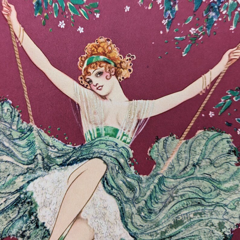 May include: Vintage illustration of a woman on a swing, wearing a green dress and headband. The artwork features a burgundy background with floral accents and a whimsical, art deco style.