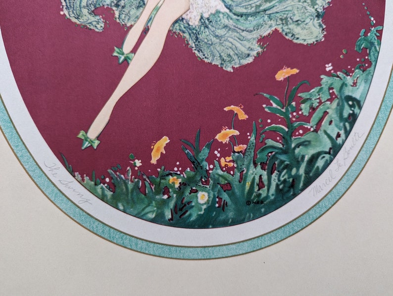 May include: An art print titled "The Swing" featuring a stylized illustration of a figure in a flowing dress. The artwork has a burgundy background with green and yellow floral accents and a light green border.