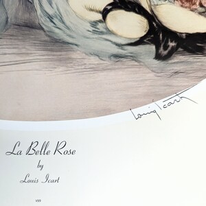May include: A print of "La Belle Rose" by Louis Icart. The artwork features a woman with a floral arrangement and a soft, muted color palette. The artist's signature is visible in the lower right corner. The title and artist's name are printed below the artwork.