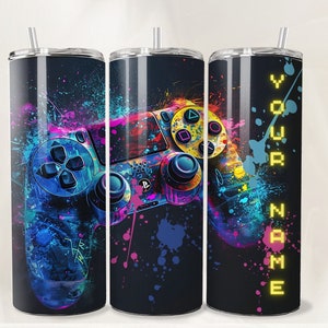 May include: A black and blue stainless steel tumbler with a colorful abstract design featuring a video game controller. The text "YOUR NAME" is printed in yellow on the side of the tumbler.