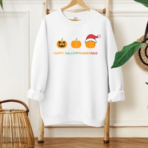 Happy Hallowthanksmas sweatshirt with pumpkins for Halloween, Thanksgiving, and Christmas