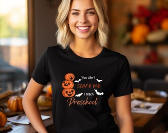 May include: Black t-shirt with a graphic of three stacked jack-o'-lanterns and the text "You can't scare me I teach Preschool".