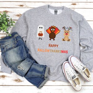 Happy Hallowthanksmas sweatshirt with ghost, turkey, and reindeer for Halloween, Thanksgiving, and Christmas