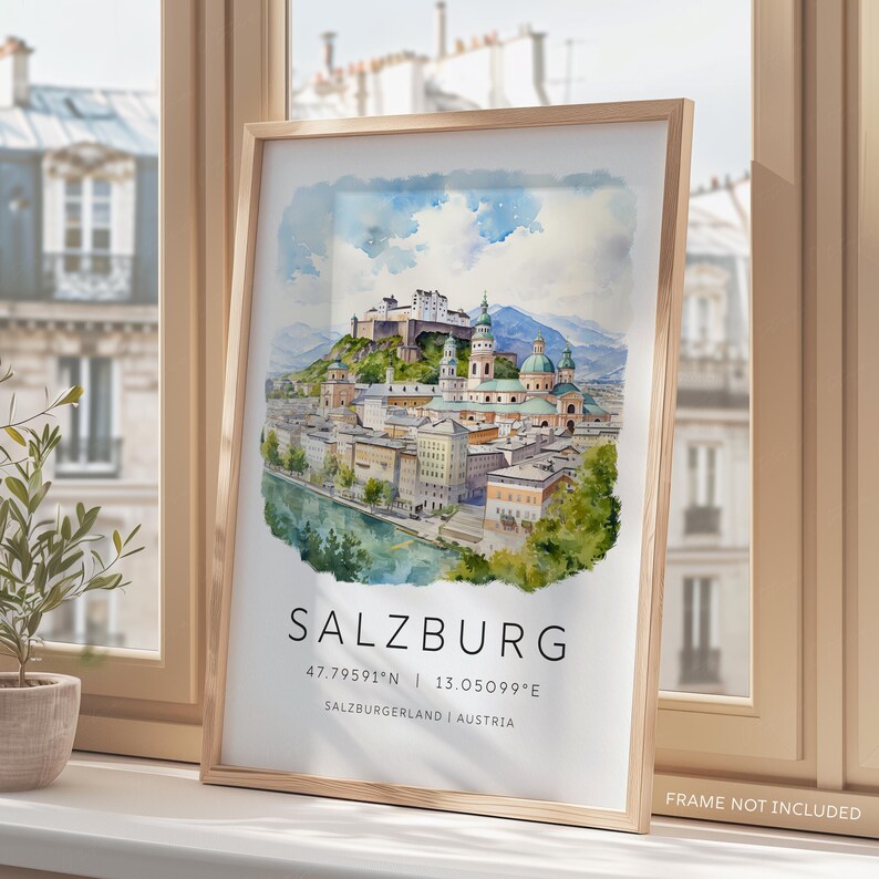 Peut inclure: Une peinture &agrave; l'aquarelle de Salzbourg, en Autriche. La peinture repr&eacute;sente l'horizon de la ville, y compris la forteresse de Hohensalzburg, la cath&eacute;drale de Salzbourg et la rivi&egrave;re Salzach. La peinture est encadr&eacute;e dans un cadre en bois clair. Le texte "SALZBURG 47.79591&deg;N | 13.05099&deg;E SALZBURGERLAND | AUSTRIA" est imprim&eacute; sous la peinture.
