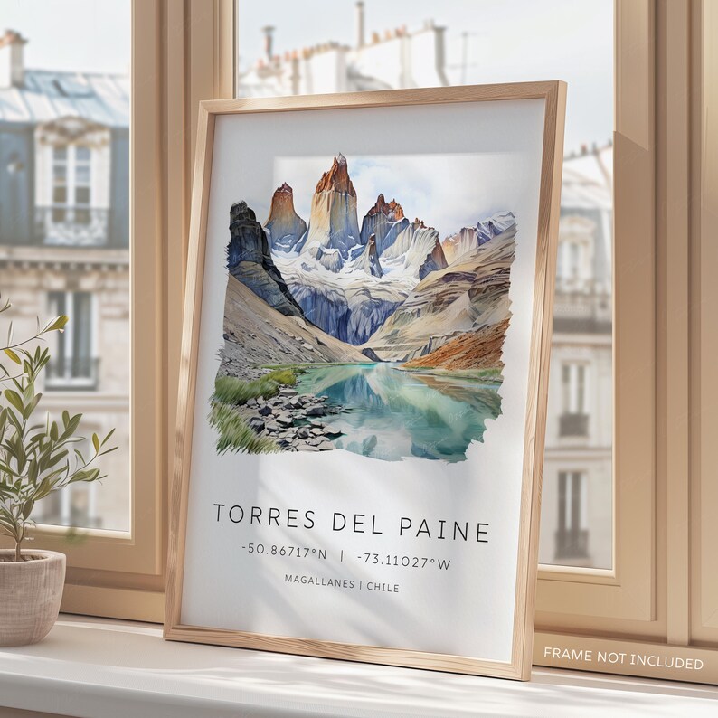 May include: A watercolor painting of the Torres del Paine National Park in Chile. The painting features a mountain range with snow-capped peaks and a turquoise lake in the foreground. The text "Torres del Paine" is written below the image, along with the coordinates -50.86717&deg;N 73.11027&deg;W and "Magallanes I Chile".