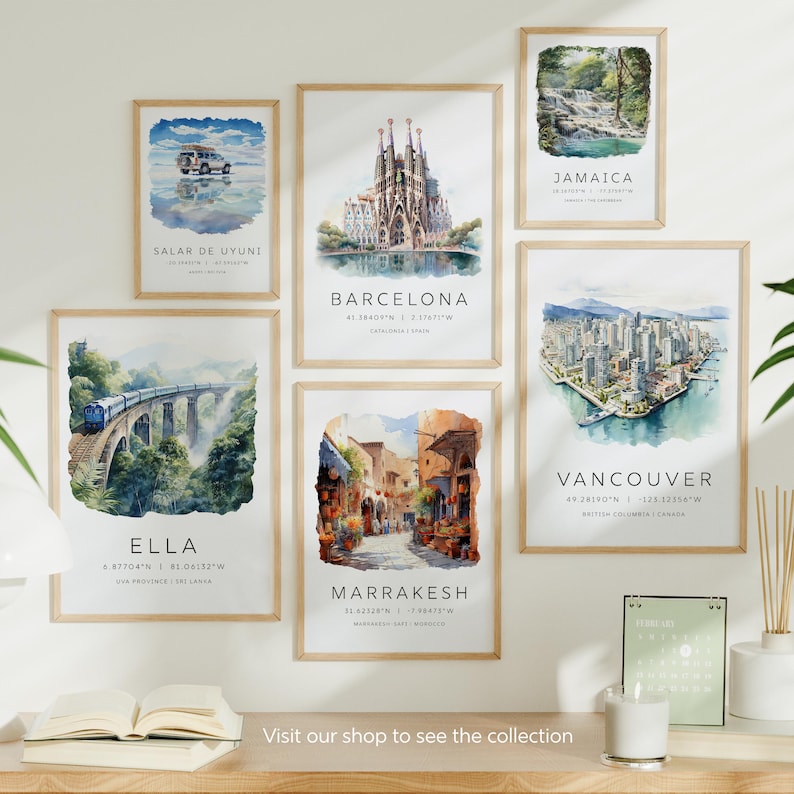May include: A collection of watercolor paintings depicting various locations around the world. Each painting features a unique scene, including a salt flat, a cathedral, a waterfall, a city skyline, a street market, and a train bridge. The paintings are framed in natural wood and displayed on a white wall.