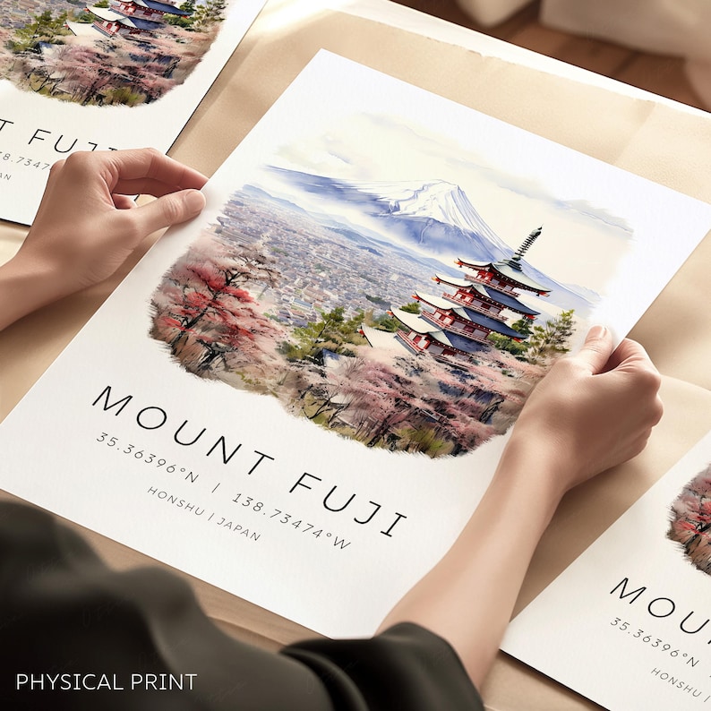 以下が含まれることがあります： 富士山と、手前にある五重塔を描いた水彩画。背景には街と桜の花が描かれている。画像の下には「MOUNT FUJI 35.36396&deg;N | 138.73474&deg;W HONSHU | JAPAN」というテキストが印刷されている。画像の下部には「PHYSICAL PRINT」という文字が印刷されている。