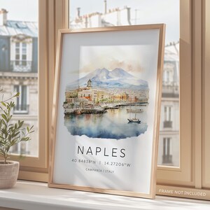 以下が含まれることがあります： ヴェスビオ山を背景に、イタリアのナポリを描いた水彩画。絵画には、建物、港、ボートのある街並みが描かれている。絵画の下には、「NAPLES」という文字が太字で書かれており、その下に「40.84838&deg;N | 14.27206&deg;W」という座標と「CAMPANIA | ITALY」という場所が記されている。
