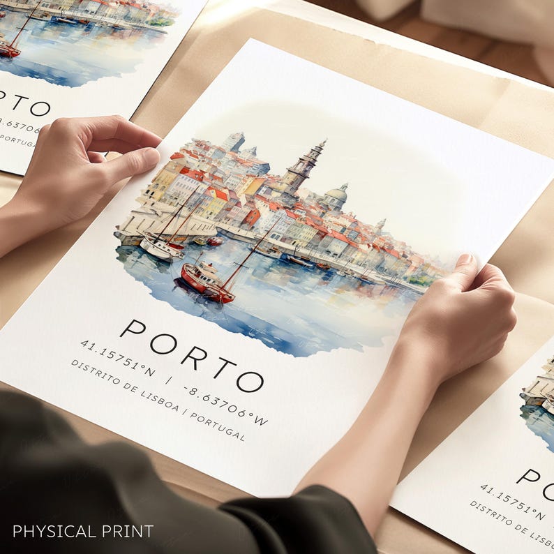 May include: A watercolor painting of the city of Porto, Portugal. The painting shows the city's waterfront with boats and buildings. The text "PORTO" is written in black at the bottom of the painting, along with the coordinates "41.15751&deg;N -8.63706&deg;W" and the text "DISTRITO DE LISBOA | PORTUGAL".