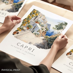 Pode incluir: Impressão em aquarela de Capri, Itália, apresentando uma cena costeira com edifícios, escadas e limoeiros. A impressão inclui as coordenadas 40.54721°N 14.24319°E e a palavra "CAPRI". O texto "PHYSICAL PRINT" está na parte inferior.