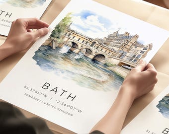 May include: Watercolor print of the Pulteney Bridge in Bath, England, with the city name and coordinates. The artwork features a detailed depiction of the bridge over a river, with a blue sky and green foliage.