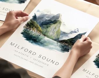 May include: A watercolor print of Milford Sound in New Zealand. The print features a scenic view of the fiord with mountains and a lake. The text "Milford Sound" is printed below the image along with the coordinates -44.67167°S 167.92704°E and the words "South Island | New Zealand".