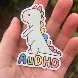 Autocollant dinosaure AuDHD (autisme + TDAH). Embrassez votre neurodiversité. Jolis autocollants pour ordinateur portable en vinyle.