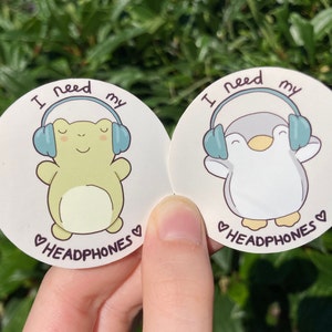 Cute stickers "I need my headphones".  Frog and penguin illustration. Actually autistic, ADHD, neurodivergent, HSP, music lover.
