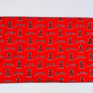 Puede incluir: Tela roja con un patr&oacute;n repetido de texto "Angels" blanco y un logotipo "A" estilizado.
