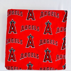 Puede incluir: Tela roja con un patr&oacute;n repetido del logotipo del equipo de b&eacute;isbol de los &Aacute;ngeles &Aacute;ngeles. El logotipo es una 'A' estilizada con alas y la palabra '&Aacute;ngeles' debajo.
