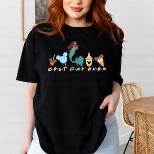 a woman standing in front of a table wearing a t - shirt that says best