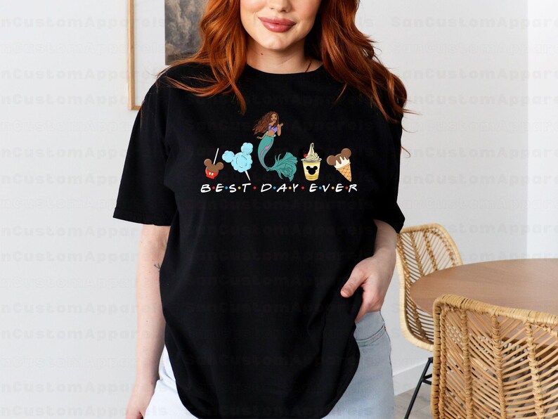 a woman standing in front of a table wearing a t - shirt that says best