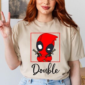 a woman with red hair wearing a deadpool t - shirt