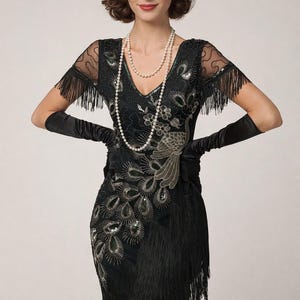 Puede incluir: Vestido negro de estilo flapper con intrincados abalorios y flecos. El vestido presenta un escote en V, mangas cortas con flecos y un diseño de pavo real. Un largo collar de perlas y guantes negros completan el look. Prenda de inspiración vintage.