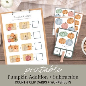 May include: A wooden clipboard with pumpkin addition worksheets and count and clip cards. The worksheets feature watercolor pumpkins and hay bales. A small bowl of clothespins and pumpkins are also visible.
