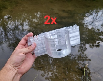 Könnte beinhalten: Zwei transparente, 3D-gedruckte Halterungen aus Kunststoff für eine Angelrute. Die Halterungen sind so konzipiert, dass sie an einem Kajak oder Boot befestigt werden können.