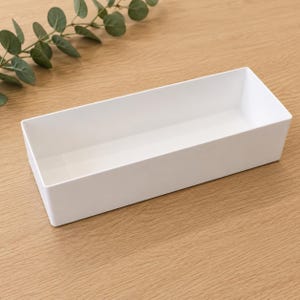 May include: A rectangular white storage bin with smooth, solid walls and an open top. The container features a clean, minimalist design with straight edges and a flat base, providing a simple and functional structure for organizing various items.