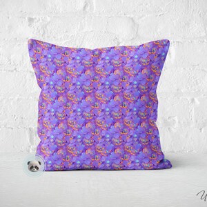 May include: Purple pillow with a repeating pattern of orange and purple jack-o'-lantern faces.