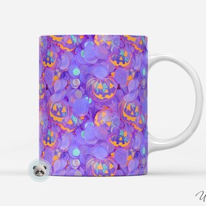 May include: A white ceramic mug with a purple and orange Halloween-themed design. The mug features a repeating pattern of jack-o'-lantern faces.