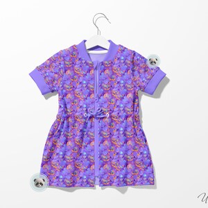 May include: A purple short-sleeved dress with a zipper closure and a drawstring waist. The dress has a colorful print of various objects, including a castle, a crown, and a heart.