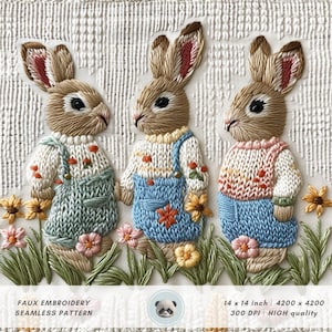 以下が含まれることがあります： 花畑の中に、セーターとオーバーオールを着た刺繍のウサギが3匹立っています。ウサギは茶色で、ピンクの耳と鼻をしています。花は黄色、ピンク、オレンジです。背景は白地に織り模様の入った布です。