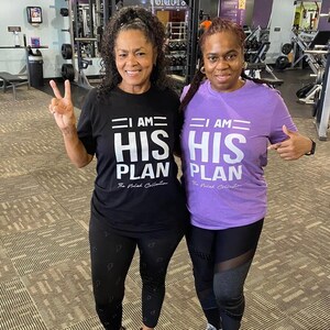 Puede incluir: Dos personas con camisetas negras y moradas con el texto "I AM HIS PLAN" en blanco. La persona de la izquierda lleva leggings negros con un patr&oacute;n y la persona de la derecha lleva leggings negros con paneles de malla. Ambas personas sonr&iacute;en y miran a la c&aacute;mara.