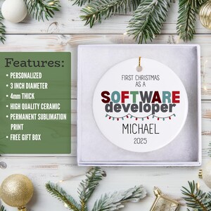 a white ornament box with a personalized ornament inside, along with a list of features for the ornament. The ornament is placed on a wooden surface, surrounded by Christmas decorations and ornaments.