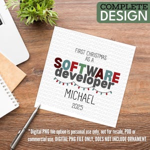 a white square card with text and graphics, placed on a wooden surface alongside a pen, a notebook, and a plant.