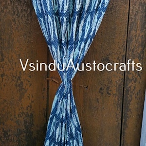 May include: A blue and white patterned fabric curtain with a fish design. The curtain is knotted in the middle and hangs in front of a wooden door. The text "VsinduAustocrafts" is visible.