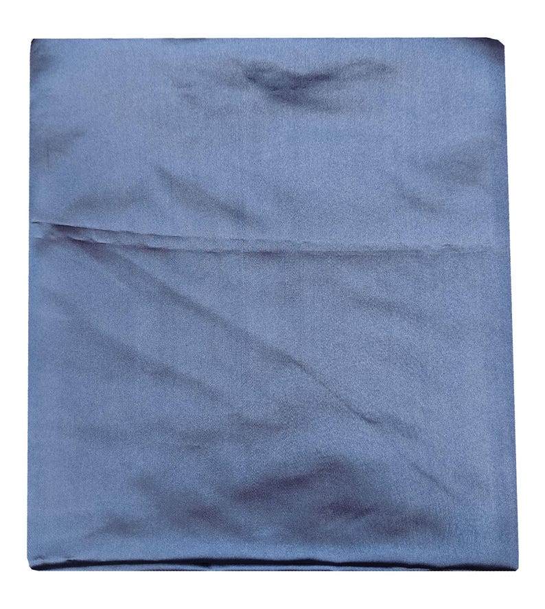 Puede incluir: Una funda de almohada cuadrada y plegada, de color azul apagado. La tela tiene un brillo sutil, lo que sugiere sat&eacute;n o seda. La funda de almohada est&aacute; cuidadosamente doblada, con una costura visible en el medio.
