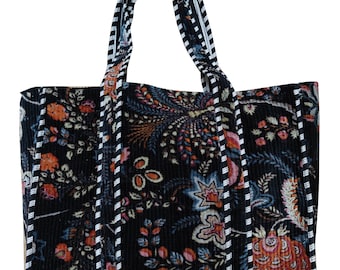 May include: Black tote bag with a floral print and white and black trim. The bag has two handles.