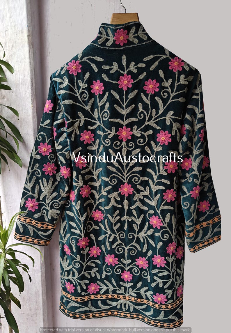 Op de afbeelding: Donkergroene geborduurde jas met roze bloemen- en bladerenpatroon. De jas heeft lange mouwen en een hoge kraag. Het borduurwerk is in roze, grijze en gouden tinten. De tekst "VsinduAustocrafts" is zichtbaar.
