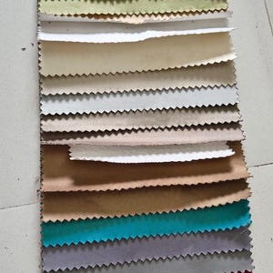 May include: A fabric swatch display with a range of colours and textures. The top section reads "BLACKOUT" and includes the "HIMANI SALES" logo. The swatches vary from neutral tones to vibrant hues, showcasing different materials for home decor.