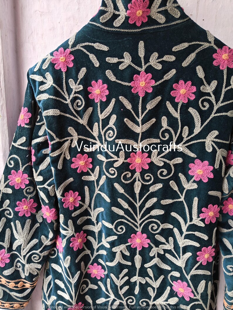 Op de afbeelding: Donkerblauwe jas met ingewikkelde bloemenborduurwerk. De jas heeft roze bloemen en zilvergrijze bladeren, waardoor een gedetailleerd patroon ontstaat. De mouwen en kraag zijn zichtbaar en tonen het vakmanschap. De tekst "VsinduAustocrafts" is zichtbaar.