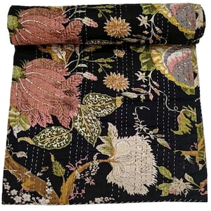 Puede incluir: Colcha floral negra con grandes estampados de flores y hojas rosas, crema y verdes. La colcha está enrollada en la parte superior, mostrando el diseño detallado. Se ven costuras blancas.