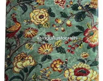 May include: A square textile with a floral pattern in shades of yellow, red, and green. The design includes large flowers, berries, and a bird perched on a branch. The text "VsinduAustocrafts" is visible.