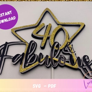 Può includere: Una stella dorata con glitter con il numero 40 al suo interno e le parole "& Fabulous" in nero con un contorno bianco. Il design è stratificato con un contorno bianco e nero.