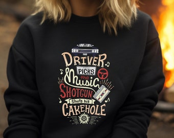 Könnte beinhalten: Schwarzer Pullover mit einem grafischen Aufdruck eines Autos und dem Text "Driver Picks the Music Shotgun Shuts his Cakehole".