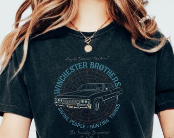 May include: Black t-shirt with a vintage-style graphic of a car and the text "Winchester Brothers Saving People Hunting Things The Family Business Got You!"
